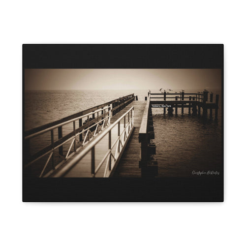 This sepia-toned scene captures a quiet moment of transition where the world seems to pause. A wooden dock stretches out with steady purpose, its leading lines drawing the eye deep into a dense, mystical fog. Rather than an empty abyss, the mist feels like a "tangible white darkness" that simplifies the landscape into a dreamlike space of absolute stillness.
